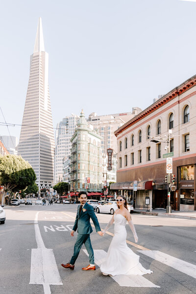 newlyweds walking in city crosswalk