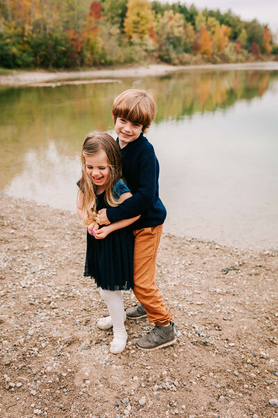 brother and sister playing on the beach at a fall family session at Puslinch Lake