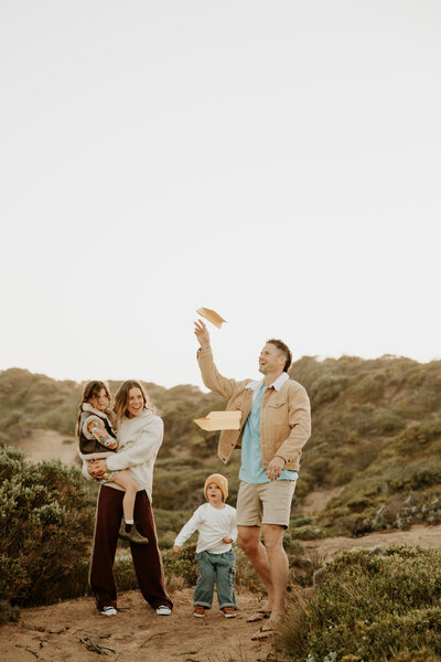 Young child jumping into a parent's arms during a family photoshoot, captured by Kayla Frizzell Photography