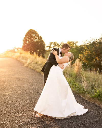A bride and groom play in the water during their engagement session on Long Beach Island, NJ