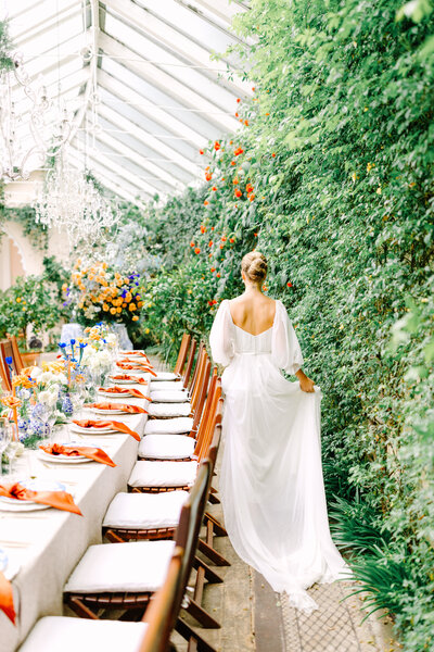bride admiring long reception table in orangery of Sezincote House wedding venue in London, photo by Anastasiya Photography - London Wedding Photographer