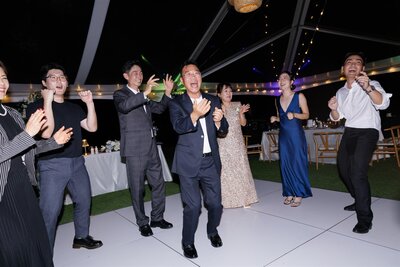 Wedding guests clapping and singing at a reception 