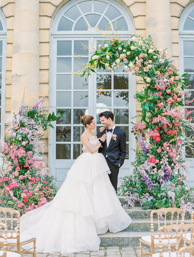 Chateau Wedding Ceremony Floral Arch by Destination Wedding Photographer Katie Trauffer