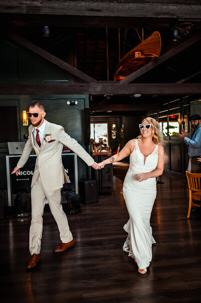 An initmate wedding couple  hold hands during entrance to reception