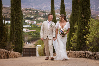 Couple walking hand in hand with a scenic Mediterranean background 