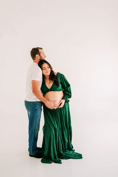Springfield MO maternity photographer Jessica Kennedy of The XO Photographer captures pregnant mom in jeans laughing in studio