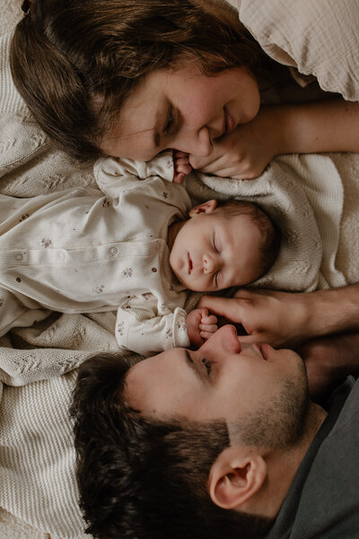kersverse mama en papa hebben hun pasgeboren kindje vast tijdens een fotoshoot bij hen thuis in Mechelen.