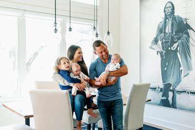 family sitting in dining area smiling for photo session