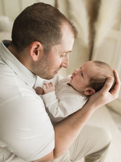 dad holding newborn baby boy for studio lifestyle session cleveland newborn photographer