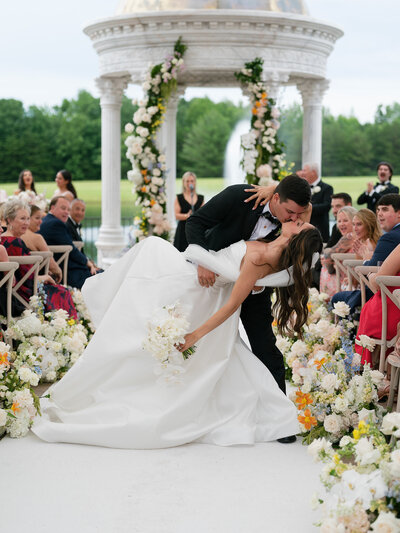 A couple kissing at the ceremony under a tent at the Conservatory at Blackberry Ridge