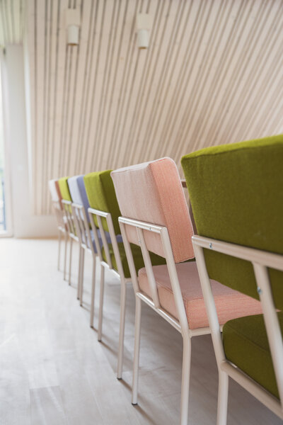 Row of colorful chairs in a vibrant working space at The Campus Alps Workbase, designed to inspire creativity and collaboration for company retreats and remote work in the heart of the Alps.
