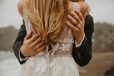 Groom embraces bride in destination wedding in the Pacific Northwest