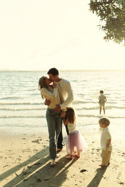 A family portrait of a family playing on the beach in Auckland. Captured by Eilish Burt Photography
