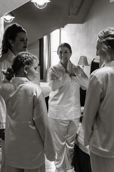 A wedding party standing around in matching pajamas smiling