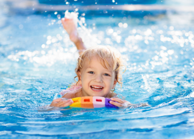 A happy toddler loves swimming and playing in the water