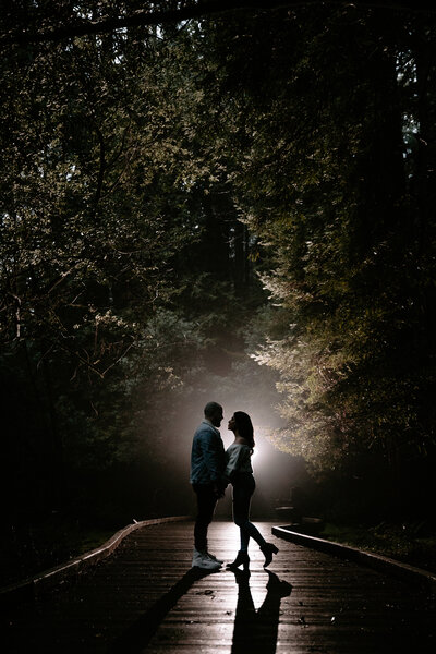 A couple poses along a path in Muir Woods
