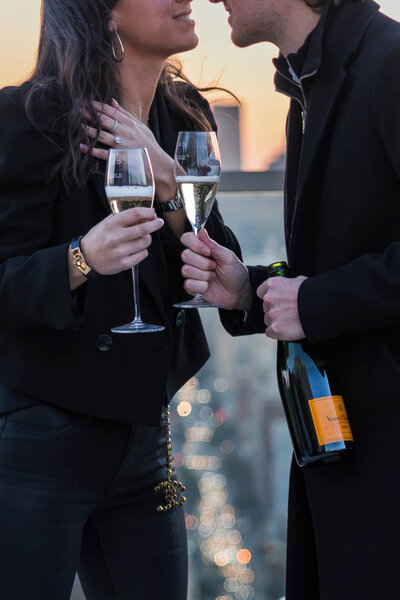 couple celebrating engagement-holding champagne.