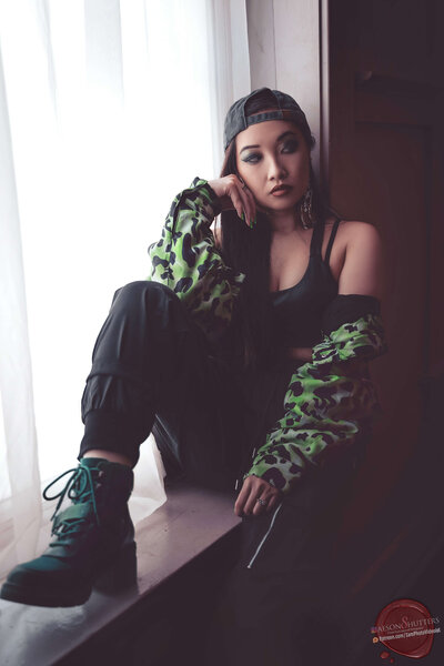 Kimmy Posed Against Window Sill in Green Camo Jacket