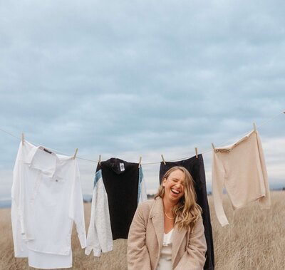 A person with their hands in their pocket looking over their shoulder and smiling 