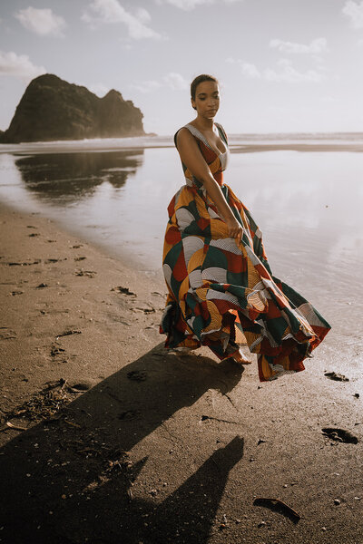 Personal branding photoshoot on the beach at golden hour showing beautiful woman in dress