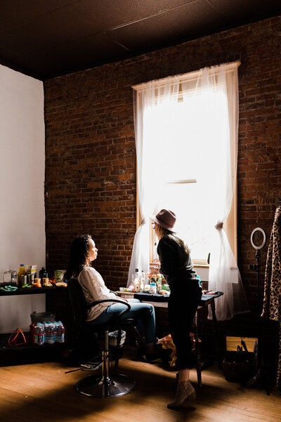 Indie producer and makeup artist Cassi Angier with a client preparing to do their makeup for set. 