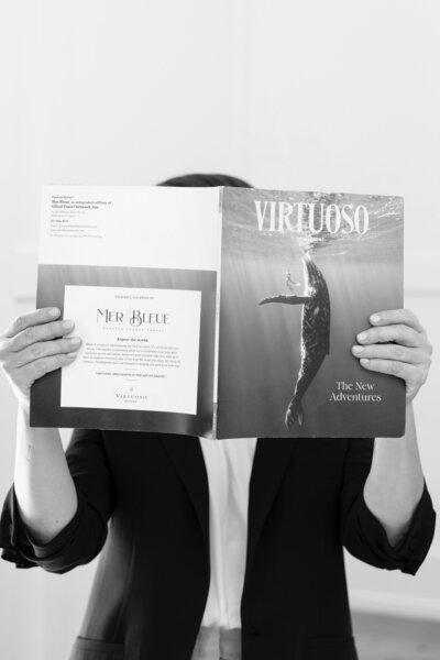 woman holding virtuoso magazine over her face