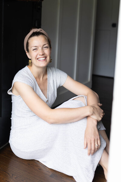 Woman sitting on the floor looking at the camera and smiling