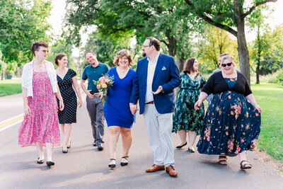 outdoor engagement pictures with man and woman holding hands on a bridge with mountains in the distance taken by denver wedding photographer