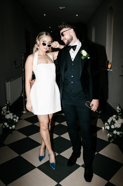 Bride pulling her sunglasses down while the groom turns his head to look at her