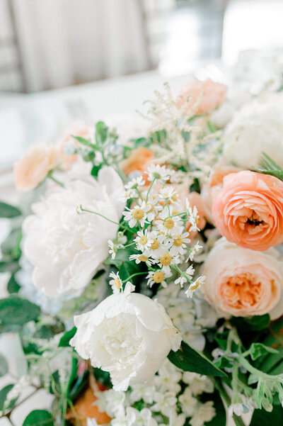 Detail photo of chamomile in a peach and white bridal bouqet.