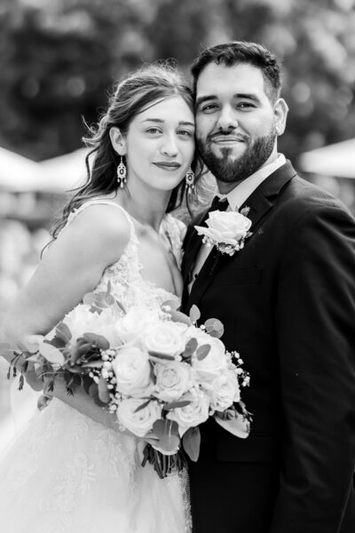 Bride in a green dress touching her nose to her fiance at their winter engagement photos at Rivercrest Farm photographed by akron ohio wedding photographer