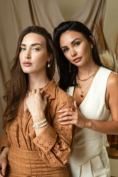 two women in neutral tones modeling Jessica Santander jewelry designs