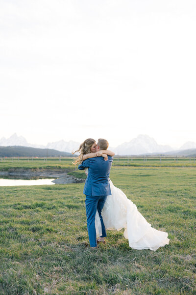 groom twirling bride around and kissing her