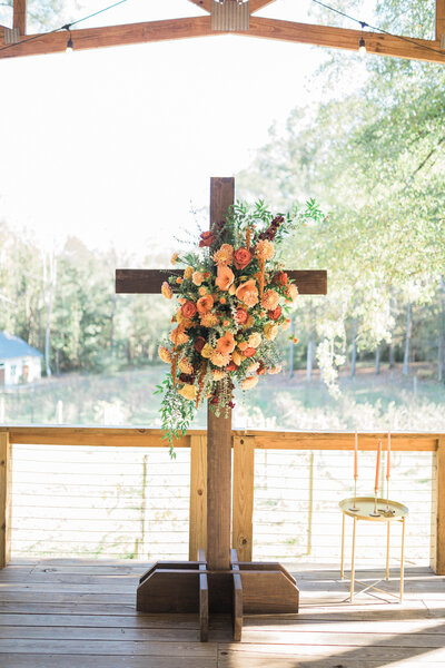 a wedding ceremony centerpiece with cross and florals at north georgia wedding venue