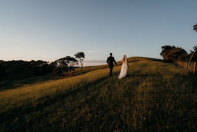 A bride and groom walking away in a wedding photoshoot in Auckland during their wedding photoshoot with Tashina Narelle Photo + Video