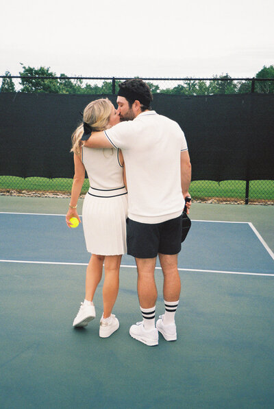 engagement photography of couple on tennis court