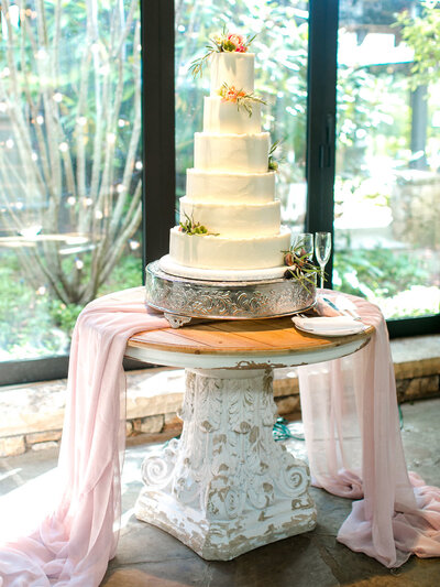 wedding cake table decorated with dishes and white flowers