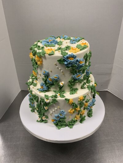 top of wedding cake with intricate pink flowers on top