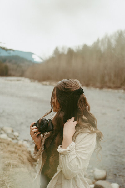 self portrait of a girl holding a camera looking away