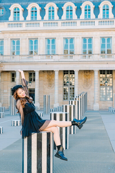 Stylish solo woman wearing a French beret, dress, and Doc Martens during a Paris photoshoot near the Eiffel Tower, Louvre, and Palais Royal.