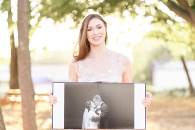 Liz Courtney, Nashville wedding photographer holding a wedding album