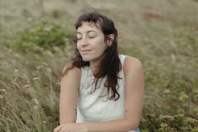 Heather smiles serenely in a field of tall grass