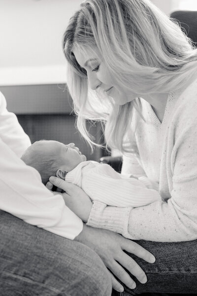 New parents hold their baby during a luxury newborn photoshoot at home.