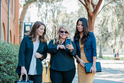 Three women looking at a phone.