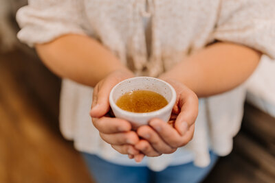 Kenna holding a cup of bone broth