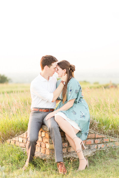 Engaged couple holding hands and laughing in black and white
