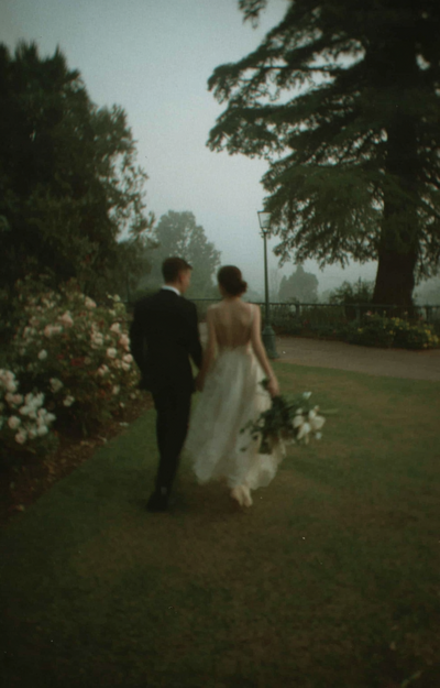 u8487914977_a_wedding_couple_walks_across_the_lawn_in_their_t_5b6abbcd-3989-4066-914e-4b4dfca5fb99_2