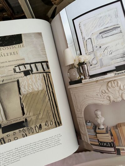 An open interior design book displaying a two-page spread with thoughtfully curated imagery and text, showcasing refined aesthetics and design inspiration.