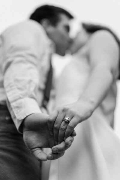 black and white image bride and groom holding handss