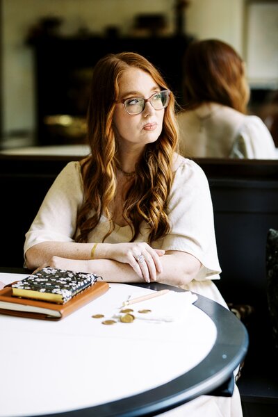 monica sitting at table looking to the side